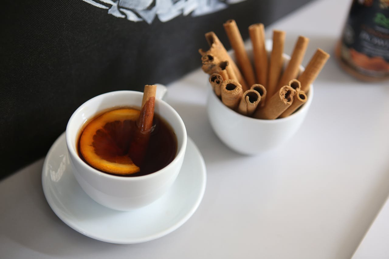 Crafting Captivating Headlines: Your awesome post title goes here A white cup of cinnamon-flavored tea with a citrus slice, accompanied by cinnamon sticks.